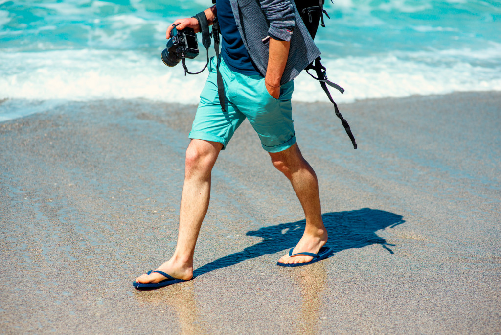 A photographer walking at the beach