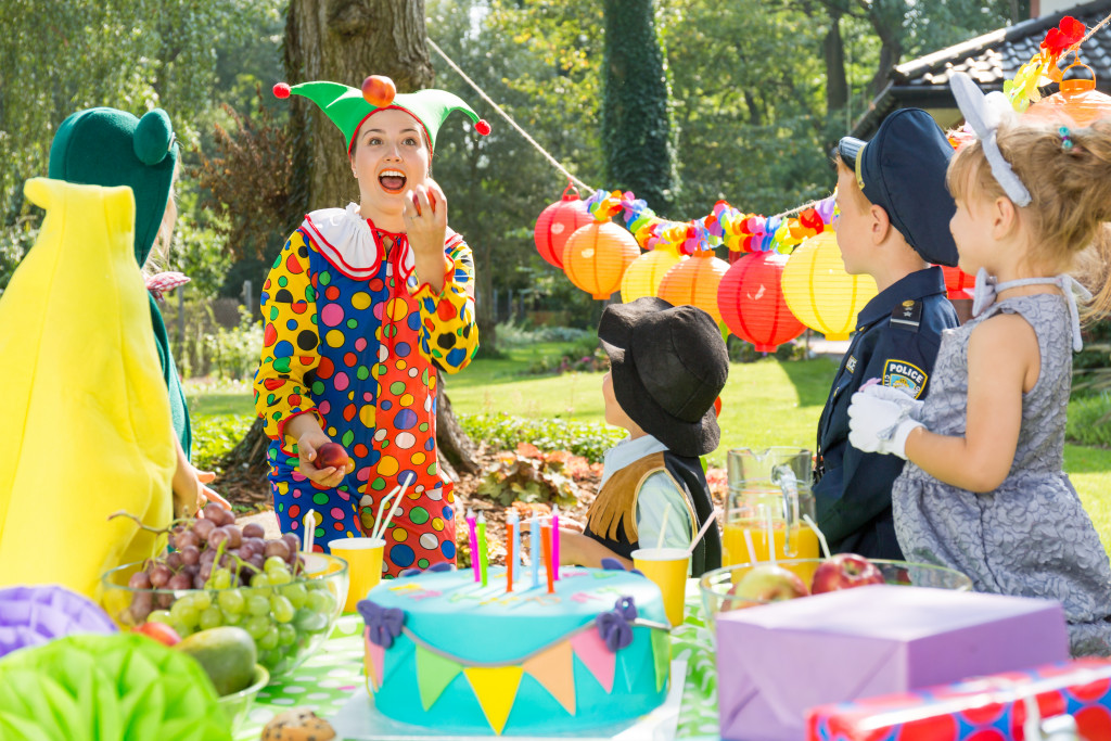 A party entertainer juggling in front of kids during a party